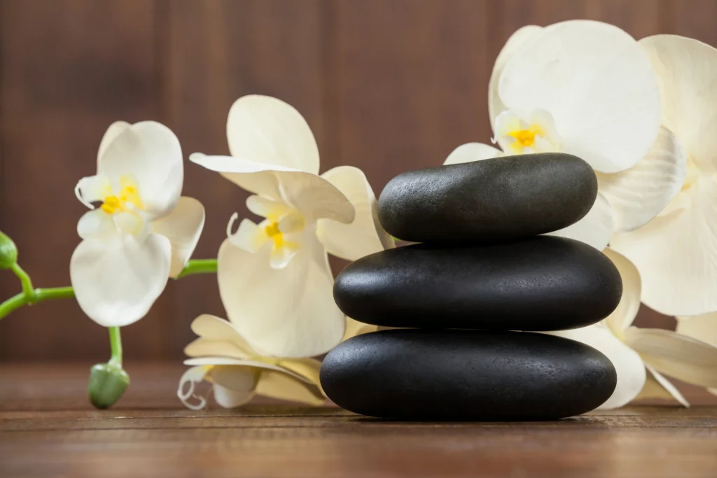 Stacked black spa stones with white orchids