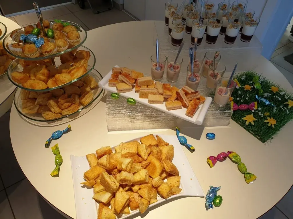 Dessert table with pastries, mousse cups, and candy
