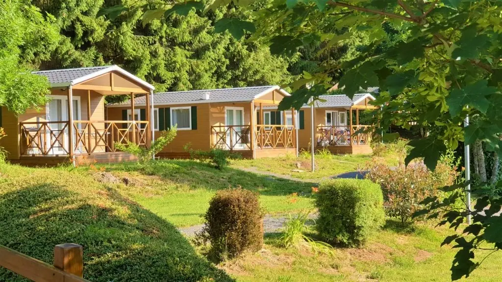 Row of wooden cabins surrounded by lush greenery