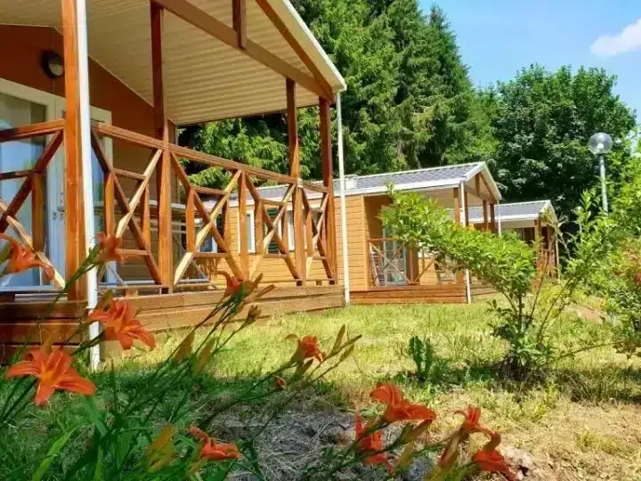 Wooden cabins with porches and garden flowers