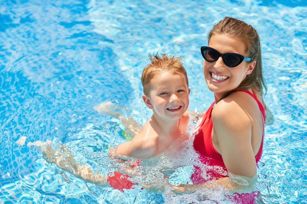 Mother and son smiling in swimming pool