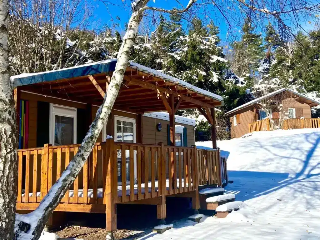 Wooden cabin with porch in snowy forest