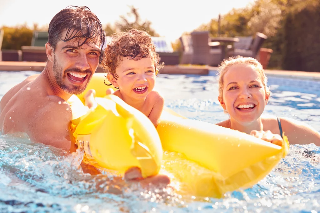 Family smiling in pool with yellow float