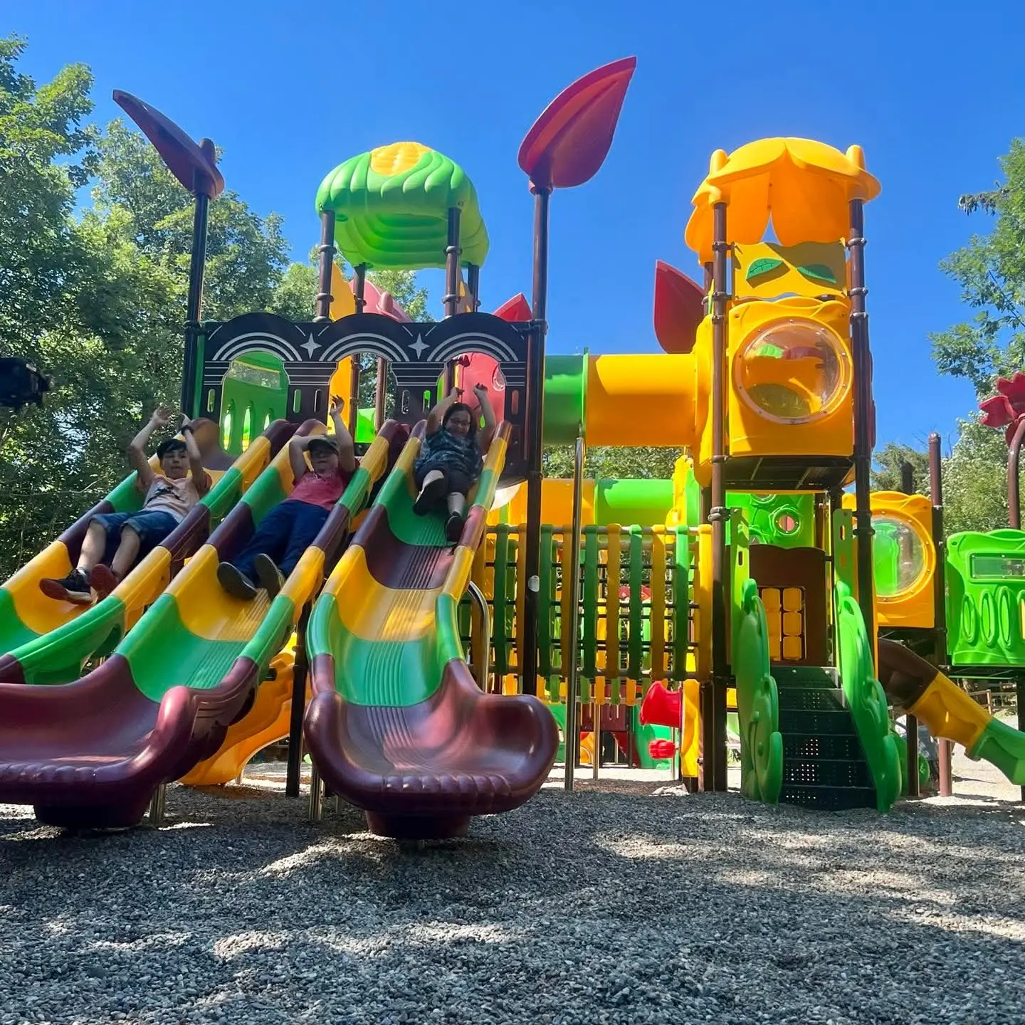 Children sliding down colorful playground slides