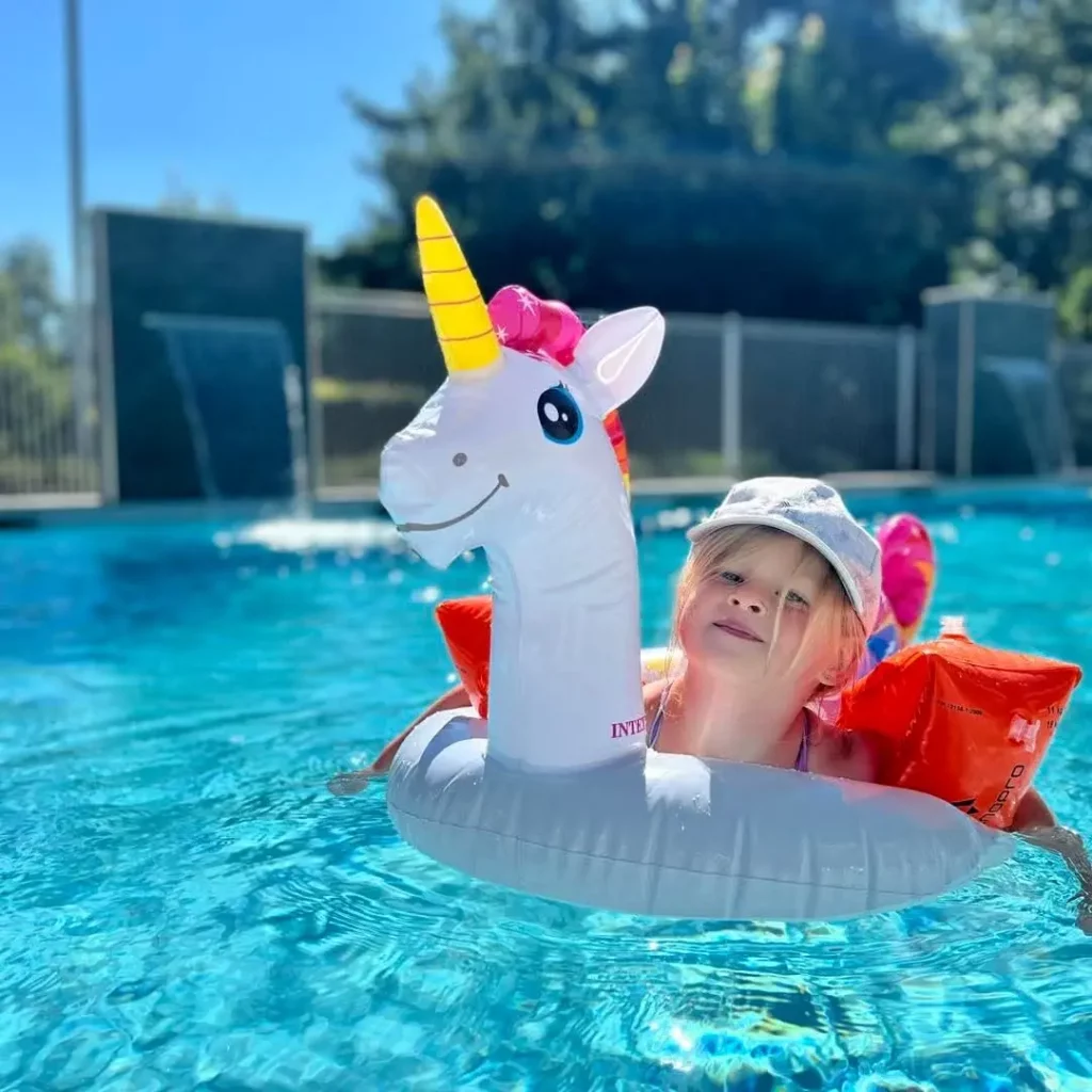 Child floating in pool with unicorn inflatable
