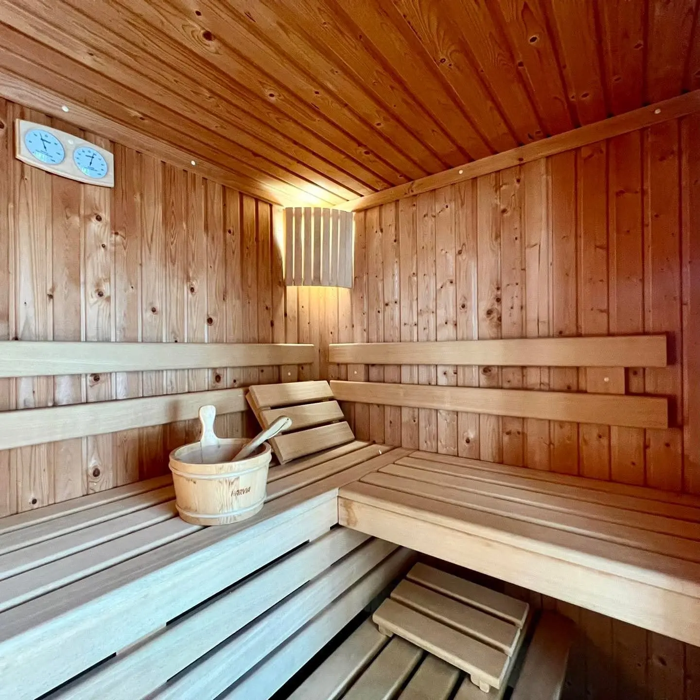 Wooden sauna interior with benches and bucket