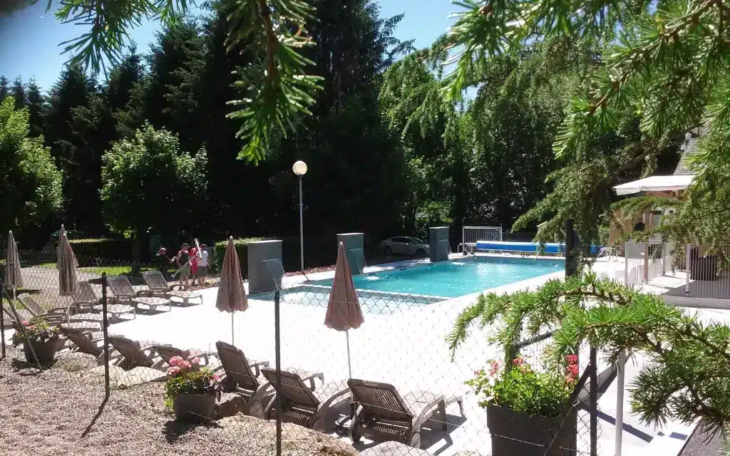 Outdoor swimming pool with lounge chairs and trees