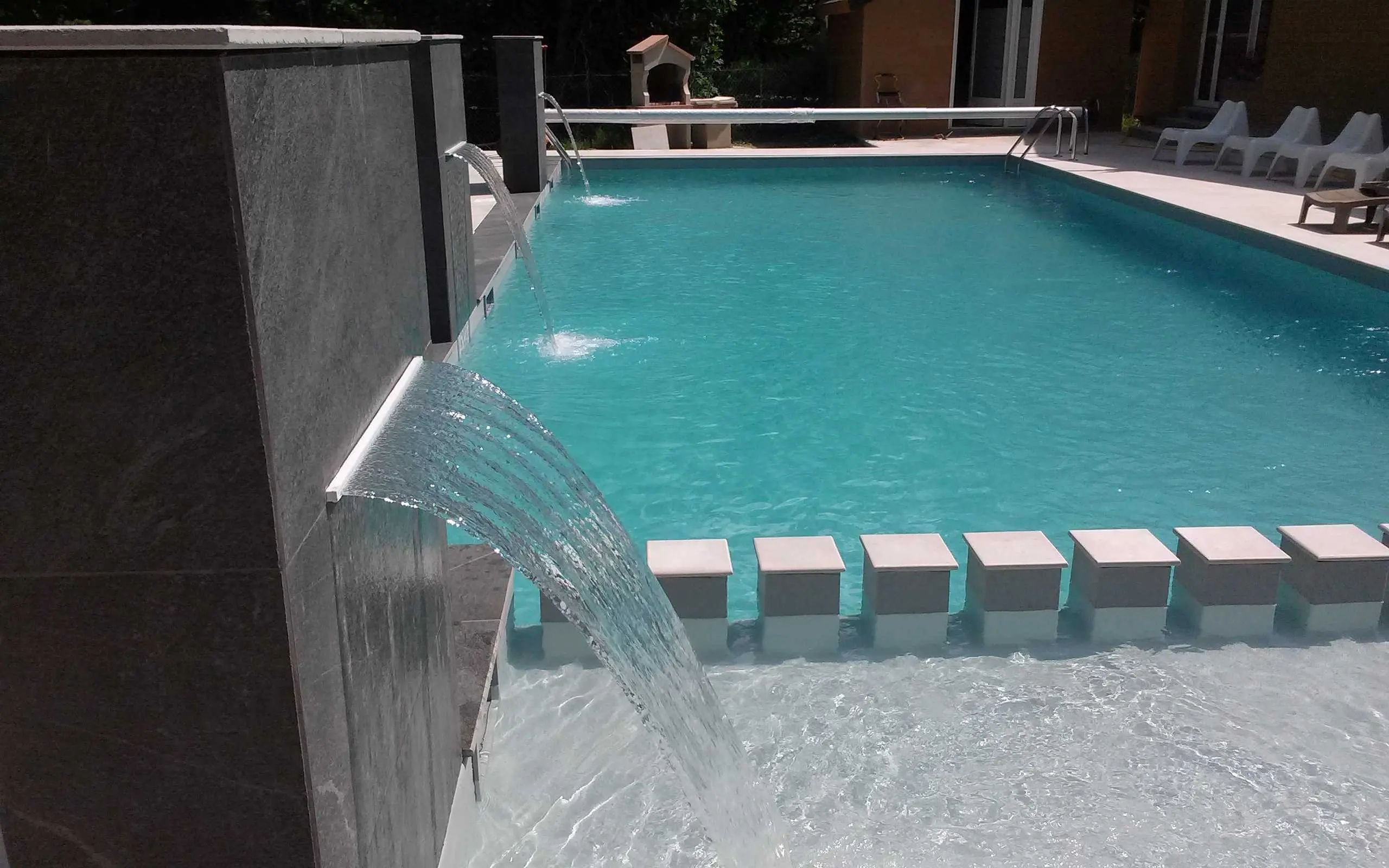 Modern outdoor pool with cascading water features