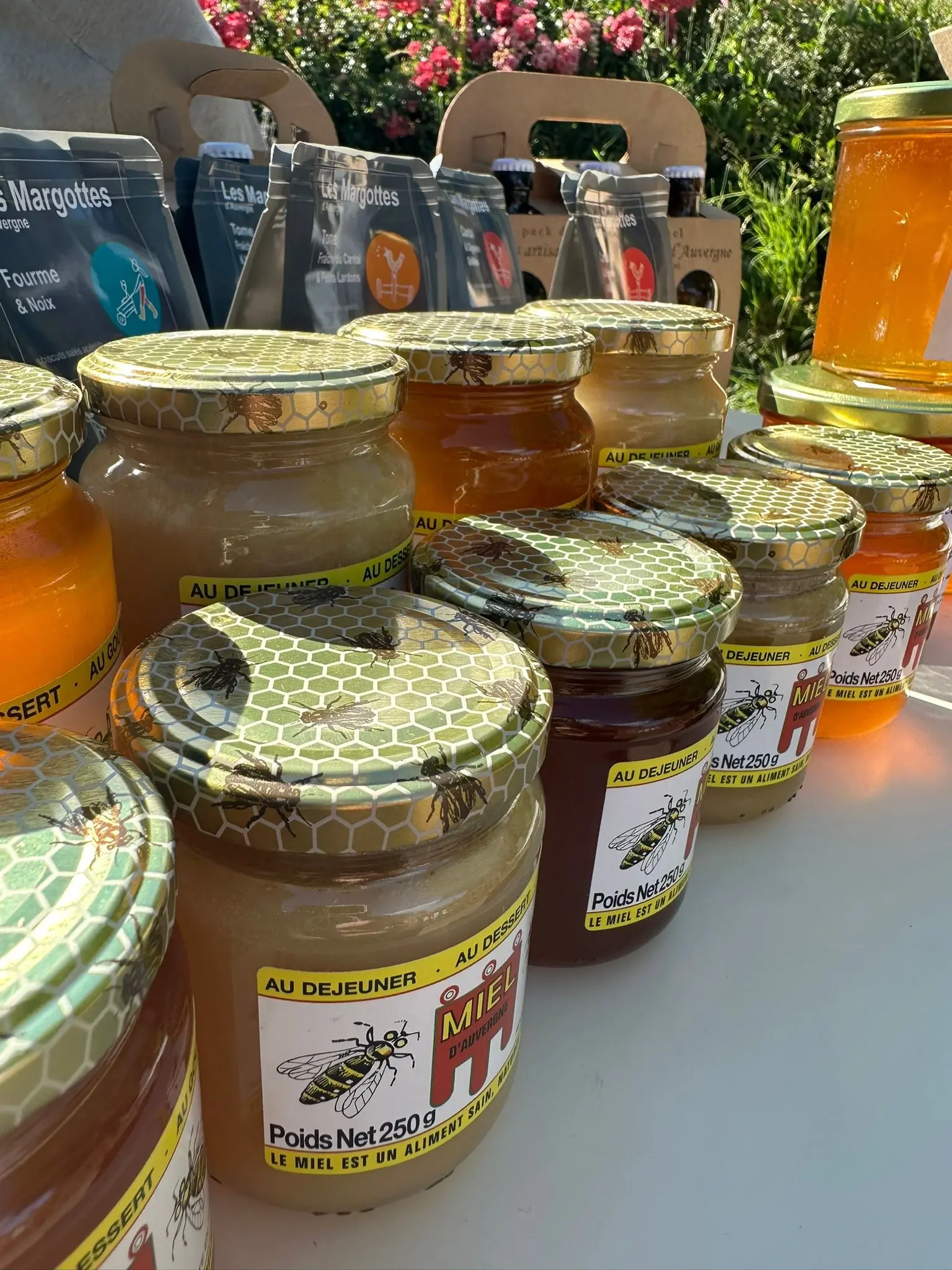 Jars of honey displayed on outdoor market table