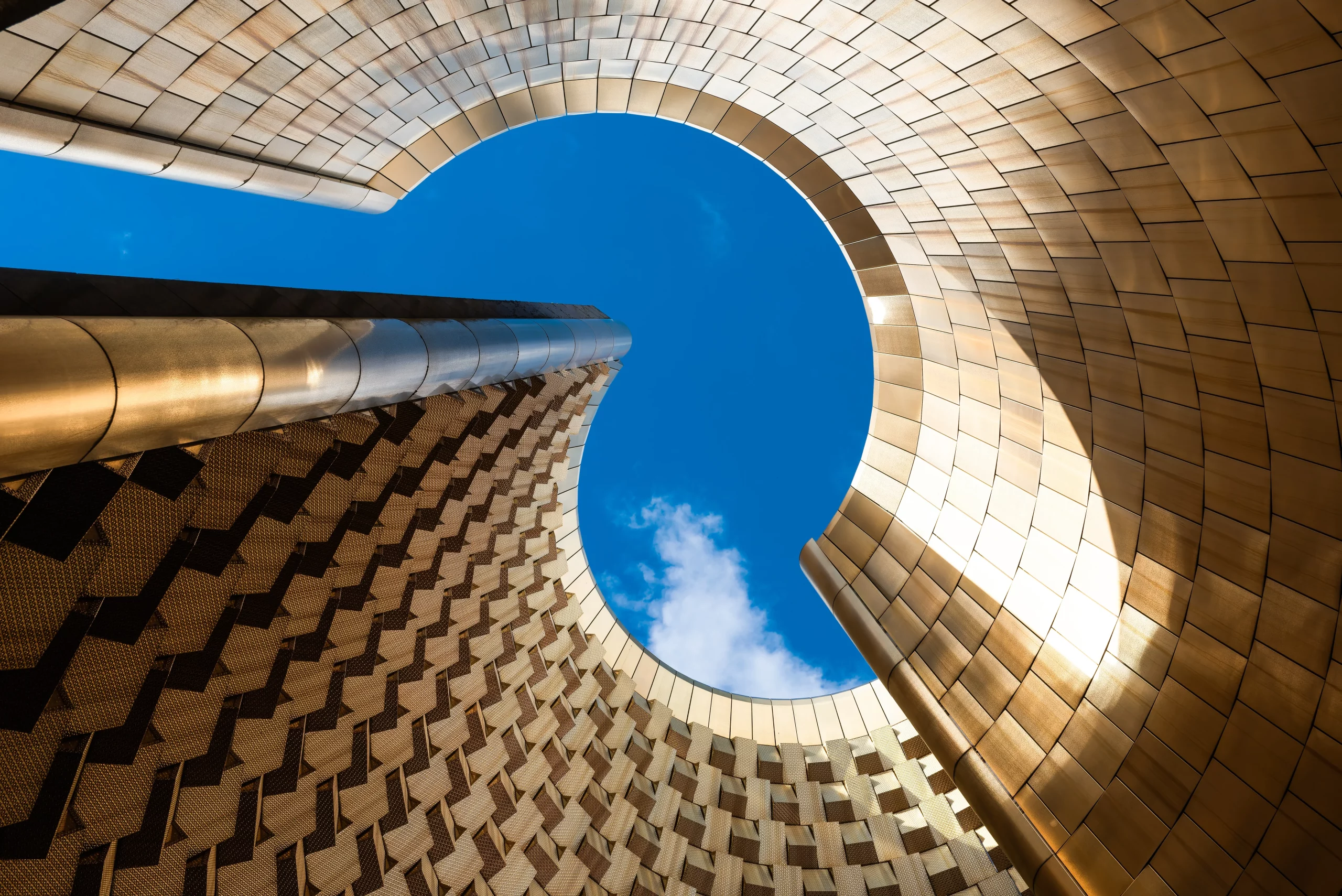 Curved golden architecture framing blue sky above
