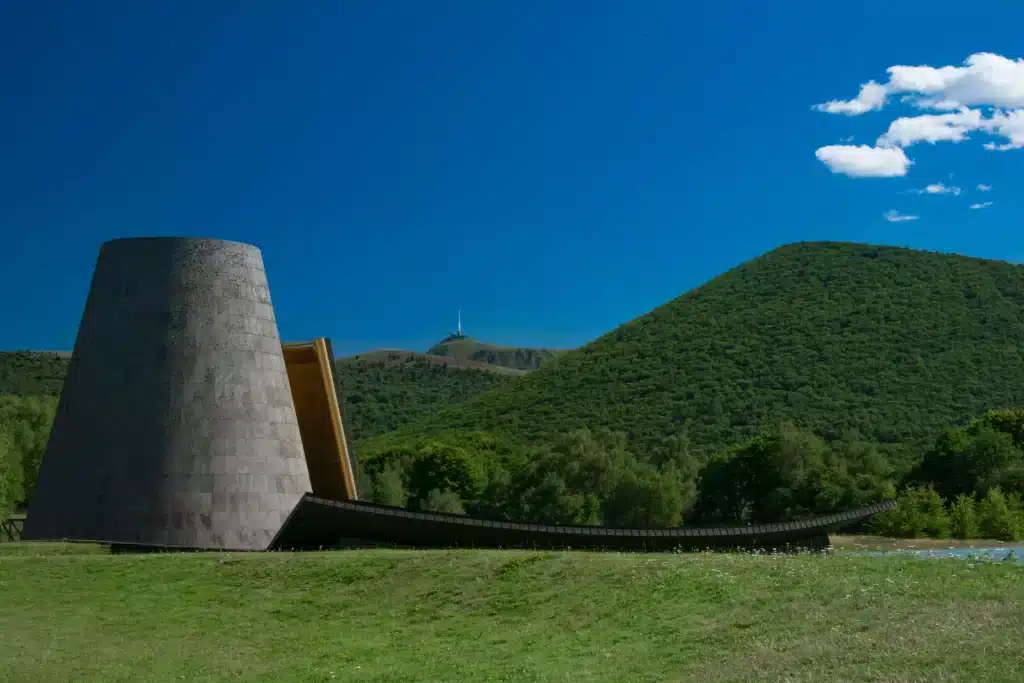 Modern concrete structure with green hills backdrop